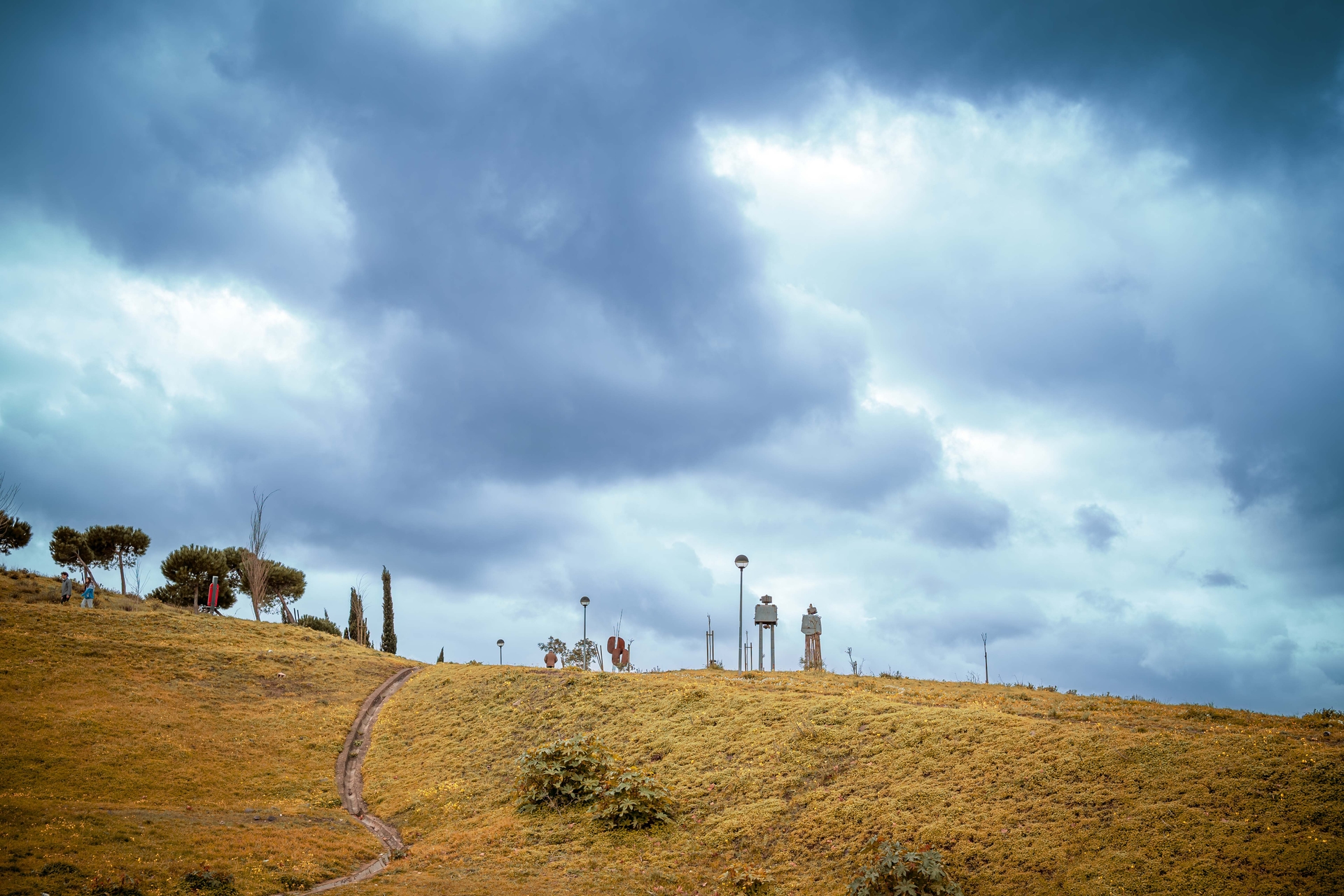 a hilltop with two figures in the horizon