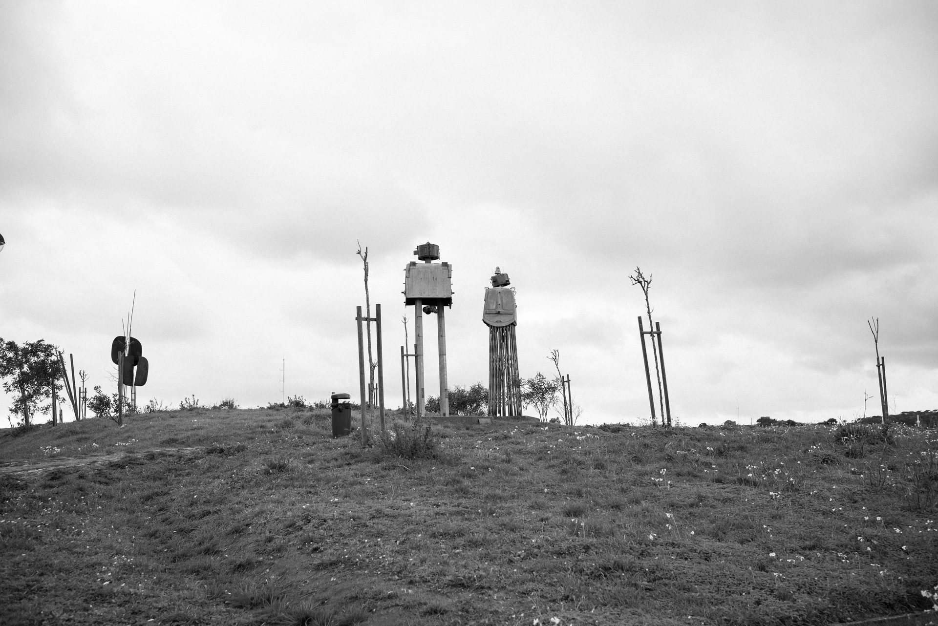 metal sculpture of two robots on top of a hill